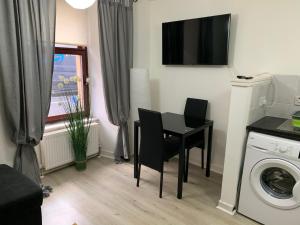 een kleine kamer met een tafel en een wasmachine bij 42 NELSON ST in Largs