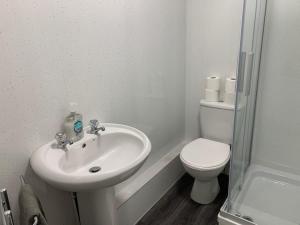 a white bathroom with a toilet and a sink at 42 NELSON ST in Largs