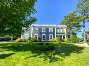 a large blue house with a fountain in the yard at Gateways Inn in Lenox