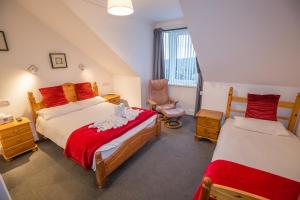 een slaapkamer op zolder met 2 bedden en een stoel bij Granite City Guest House in Aberdeen