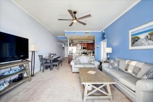 a living room with a couch and a flat screen tv at Laketown Wharf #2023 by Book That Condo in Panama City Beach