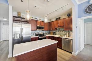 a kitchen with wooden cabinets and stainless steel appliances at Laketown Wharf #2023 by Book That Condo in Panama City Beach