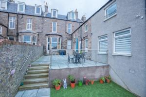 un cortile di un edificio con patio con piante di Granite City Guest House ad Aberdeen