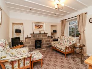 a living room with couches and a fireplace at 7 Scarah Bank Cottages in Ripley