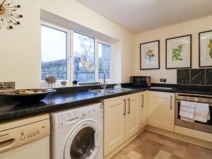 a kitchen with a washing machine and a sink at 7 Scarah Bank Cottages in Ripley