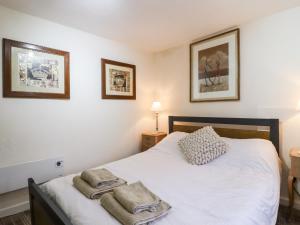 a bedroom with a white bed with two towels on it at 7 Scarah Bank Cottages in Ripley