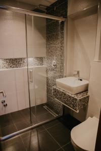 uma casa de banho com um chuveiro, um lavatório e um WC. em Saray&App em Sarajevo