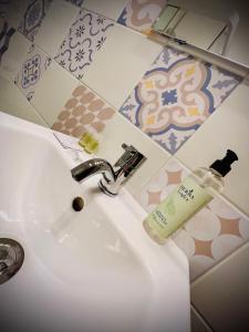 a bathroom sink with a bottle of soap on it at Crops City Stay Apartment 14 in Trieste