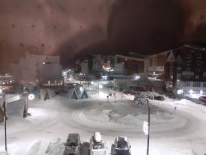a parking lot covered in snow at night at Apartman" AROMA 2 "Bjelasnica in Bjelašnica