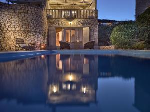 a villa with a swimming pool at night at Orfos Villas in Agios Nikolaos