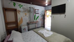a bedroom with a bed with towels on it at Recanto dos Pássaros - Sana Chalés in Sana