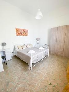 um quarto com uma cama e piso em madeira em Gioffredi Apartment em Manduria