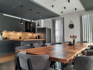a dining room with a large wooden table and chairs at Вила Bora Vista 1 in Tsigov Chark