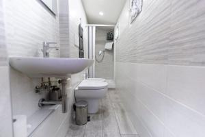 a white bathroom with a sink and a toilet at Contrasto Apartments in Viterbo