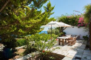 a patio with a table and an umbrella at Villa Celestina, Great for Privacy and Seclusion in Chrisopigi