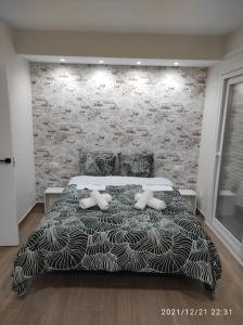 Un dormitorio con una cama en blanco y negro con una pared de ladrillo en Bonita y amplia casa con patio, en centro ciudad, en Mérida