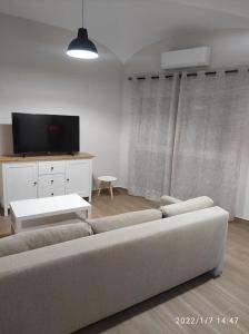 ein Wohnzimmer mit einem Sofa und einem TV in der Unterkunft Bonita y amplia casa con patio, en centro ciudad in Merida