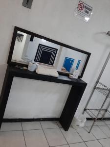 un tavolo nero con uno specchio sopra di Hotelito Ejido a Sanctórum