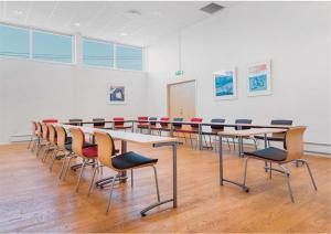 um quarto com uma mesa longa e cadeiras numa sala de aula em Gjøvik Overnatting em Gjøvik