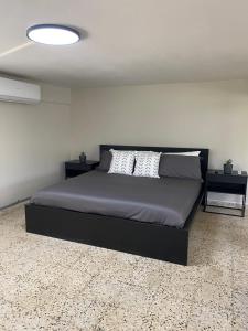a bedroom with a black bed with two night stands at Casa Isabela En Cabo Rojo in Cabo Rojo