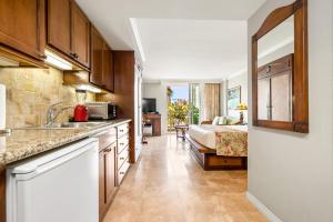 a kitchen with a sink and a bed in a room at Luana Waikiki Resort #204 in Honolulu