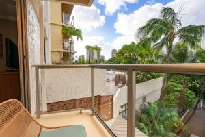 a balcony with a view of a river and palm trees at Luana Waikiki Resort #204 in Honolulu