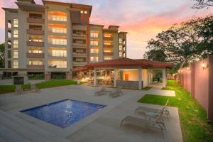 a large building with a swimming pool in front of it at Upscale 2bdr with Jacuzzi - Beach - Fast wifi - Gym in Tamarindo