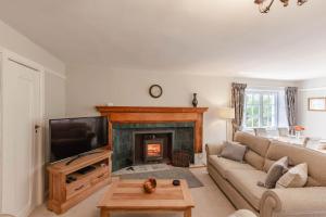 a living room with a couch and a fireplace at MacDonald Apartment in Taynuilt