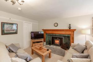 a living room with a fireplace and a tv at MacDonald Apartment in Taynuilt