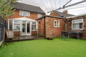 une maison avec une terrasse couverte et une pelouse dans l'établissement Cressingham House Manchester, à Manchester