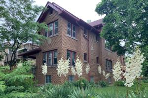 a brick house with white flowers in front of it at Chic Milwaukee Apartment in Hip Neighborhood! in Milwaukee