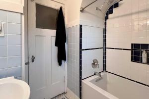 a bathroom with a tub and a toilet and a sink at Chic Milwaukee Apartment in Hip Neighborhood! in Milwaukee +18 photos