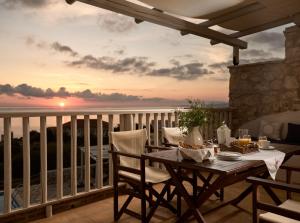 Una mesa en un balcón con vista al mar. en Orfos Villas, en Agios Nikolaos