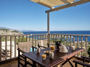 Una mesa en un balcón con vista al mar. en Orfos Villas, en Agios Nikolaos