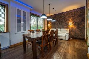 a dining room with a table and chairs and a couch at Amber Villa in Riga