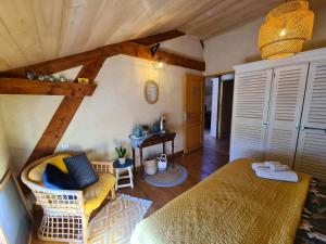 sypialnia z łóżkiem, krzesłem i stołem w obiekcie Le Coq en Repos w mieście Saint-Sylvestre-sur-Lot
