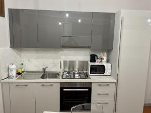 a kitchen with a sink and a microwave at APPARTAMENTO IL RESTAURO in Cuneo +1 photo