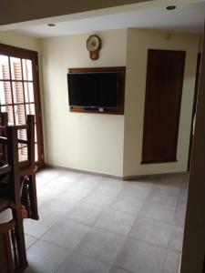 sala de estar con TV de pantalla plana en la pared en Alojamiento Marisa en Carhué