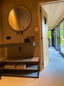 ein Badezimmer mit einem großen Spiegel an der Wand in der Unterkunft Bulsomhuys in Kampenhout