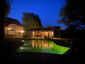 una casa con un estanque verde frente a una casa en Bulsomhuys, en Kampenhout