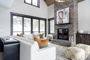a living room with a white couch and a fireplace at Spanish Peaks Highlands Cabin 18 in Big Sky
