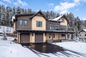 a house in the snow with trees at Spanish Peaks Highlands Cabin 18 in Big Sky