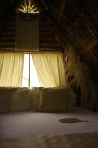 Schlafzimmer mit einem Bett mit weißer Bettwäsche und einem Fenster in der Unterkunft San Julio Campestre in Borrero Ayerbe