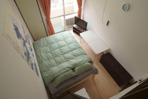 a small bedroom with a green bed and a window at Garden House Ozasa - Vacation STAY 9178 in Fukuoka