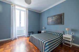 ローマにあるBB24 - 4 Fontane Private Suitesの青い壁のベッドルーム1室、ストライプの毛布付きのベッド1台が備わります。