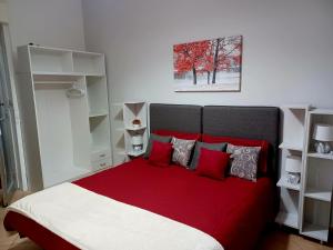 um quarto com uma cama vermelha e branca com almofadas vermelhas em Casa Donna Rosaria tra Etna e Taormina em Riposto