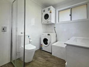 La salle de bains est pourvue d'un lavabo et d'un lave-linge. dans l'établissement Marine house, à Narooma