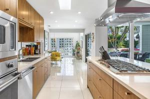 a kitchen with wooden cabinets and a stove top oven at Pink Paloma in Palm Springs