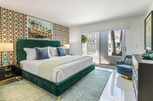 ein Schlafzimmer mit einem großen Bett und einem blauen Stuhl in der Unterkunft Pink Paloma in Palm Springs