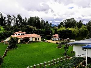 um grande pátio verde com uma casa e uma cerca em Hacienda Moncora, un lugar hermoso para toda la familia y los amigos em El Rosal